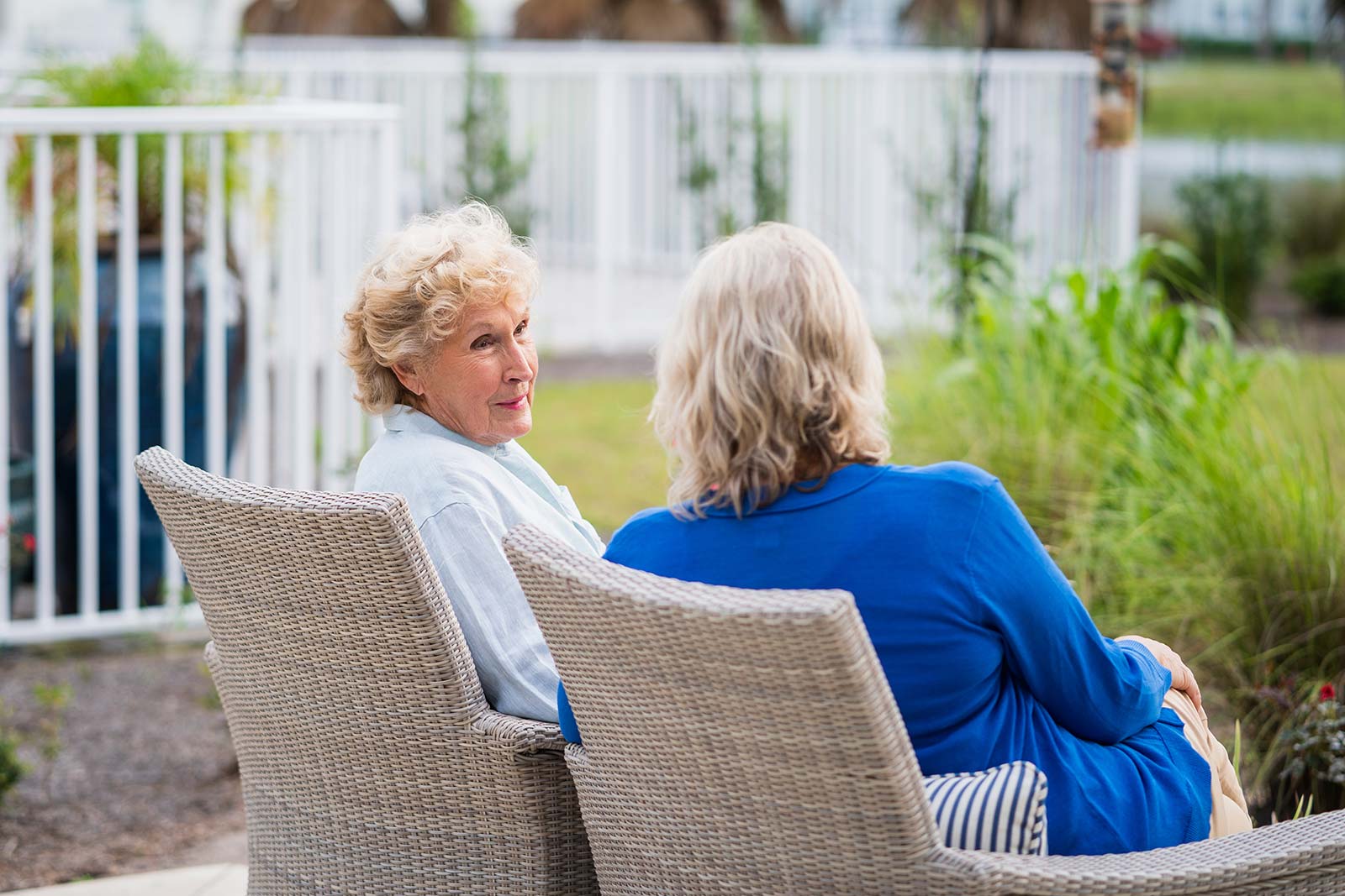 Two senior women seated on outdoor patio