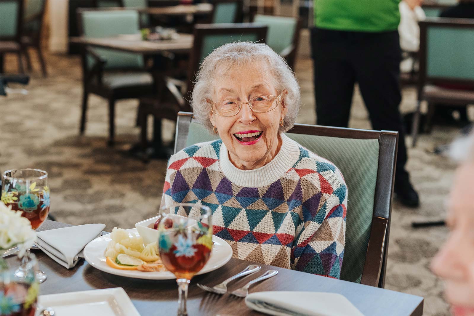Senior Woman sitting at dining room table smiling